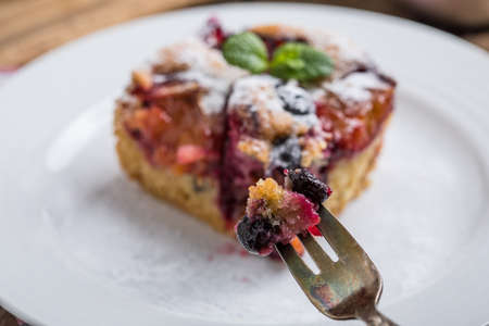 Piece of yeast dough with plums and blueberries. Small depth of field.の写真素材