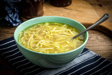 Broth - chicken soup with noodles in a bowl.の写真素材