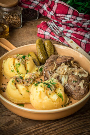 Fried chicken liver with onion served with mashed potatoes and pickled cucumber. Small depth of field.の写真素材
