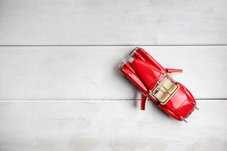 Small toy car on a white wooden background. Top view. Copy space.