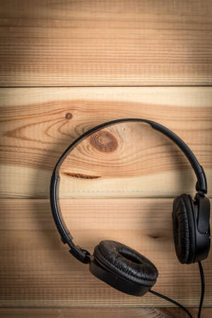 Black headphones on wooden background. Top view.の写真素材