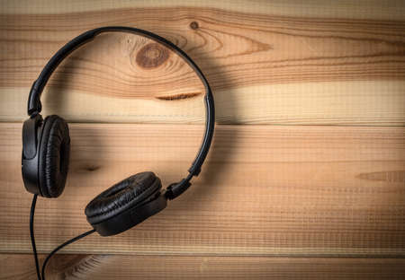 Black headphones on wooden background. Top view.の写真素材