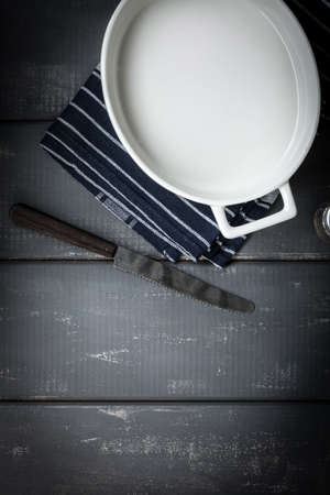 Empty dish for baking on a dark countertop. Dark light.の写真素材