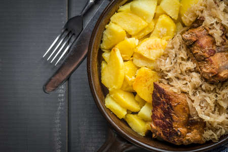 Fried ribs in sauerkraut served with roasted potatoes. Top view.の写真素材