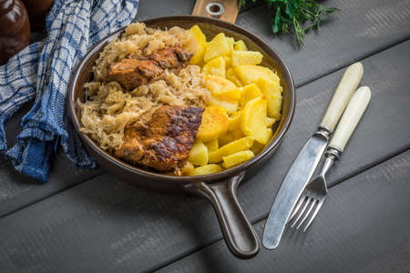 Fried ribs in sauerkraut served with roasted potatoes.の写真素材