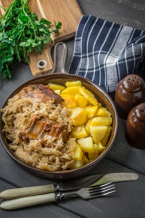 Fried ribs in sauerkraut served with roasted potatoes.の写真素材