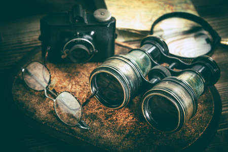 Magnifying glass and binoculars on the old map. Vintage style. Selective focus.の写真素材