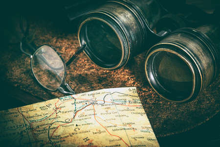Magnifying glass and binoculars on the old map. Vintage style. Selective focus.の写真素材