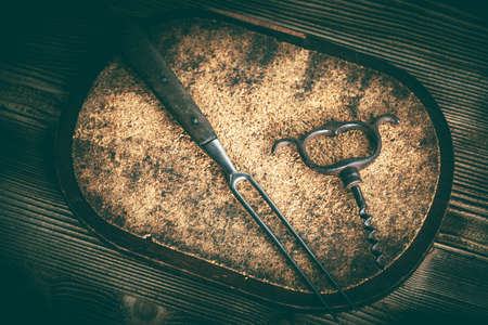 Vintage meat fork and corkscrew on wooden background.  Vintage style.の写真素材
