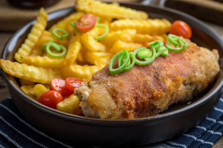 Fried chicken breast stuffed with mushrooms and cheese wrapped in ham served with fries and salad.  Small depth of field.の写真素材