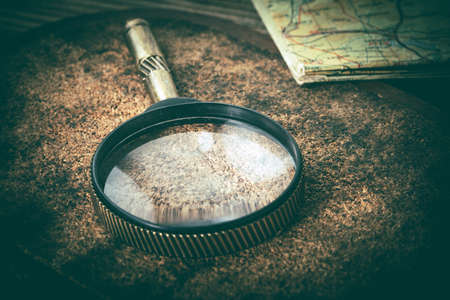 Old magnifying glass or loupe on cork background. Vintage style.の写真素材