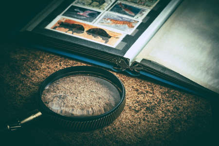 Book with postage stamps and a magnifying glass. Vintage style.の写真素材