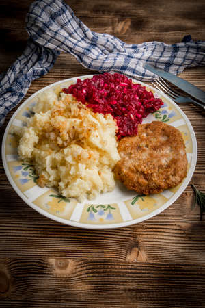 Tasty lunch: Pork cutlet with minced meat served with boiled potatoes and beetroot.の写真素材