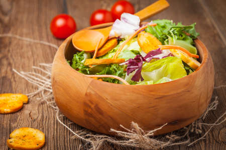 Mixed salad in a wooden bowl. Selective focus.の写真素材