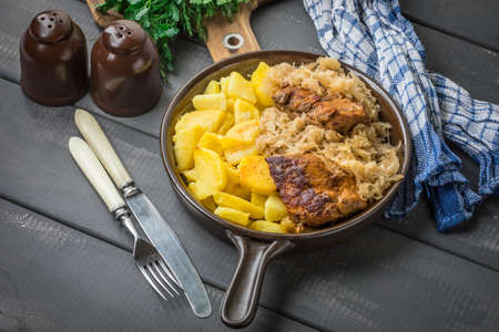 Fried ribs in sauerkraut served with roasted potatoes.の写真素材