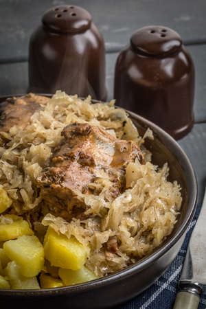 Fried ribs in sauerkraut served with roasted potatoes.の写真素材