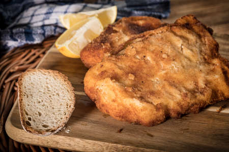 Cod fillet fried in breadcrumbs on a chopping board.の写真素材
