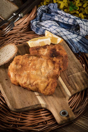 Cod fillet fried in breadcrumbs on a chopping board.の写真素材