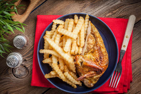 Roasted chicken with french fries on a plate. Selective focus. Top view.の写真素材