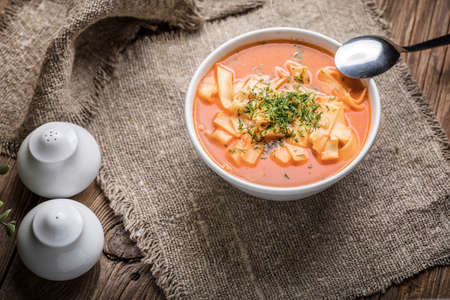 Fresh tomato soup with noodles in white bowl.の写真素材