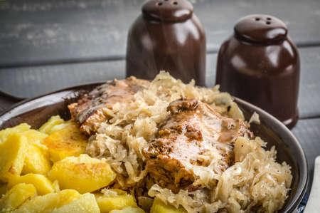 Fried ribs in sauerkraut served with roasted potatoes.の写真素材