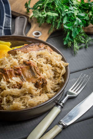 Fried ribs in sauerkraut served with roasted potatoes.の写真素材