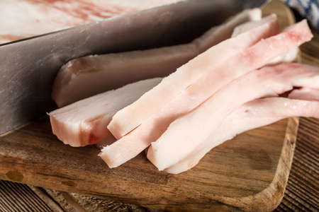Sliced fresh lard on a chopping board.の写真素材