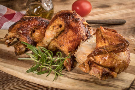 Pieces of roasted chicken on a wooden chopping board.の写真素材