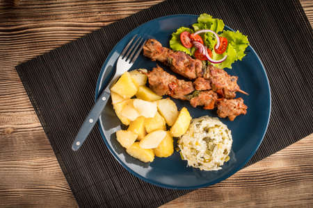 Shish kebabs - grilled meat, fried potatoes and vegetables. Top view.の写真素材