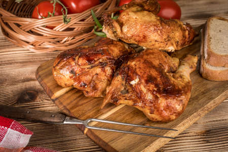 Pieces of roasted chicken on a wooden chopping board.の写真素材