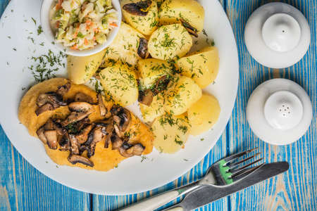 Fried chicken breast served with mushrooms and potatoes. Top view.の写真素材