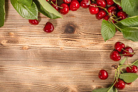 Fresh sweet cherries on a wooden background. Top view and copy space.の写真素材