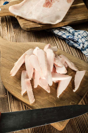 Sliced fresh lard on a chopping board.の写真素材