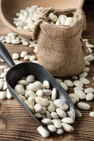 White bean in a jute bag on a wooden table.の写真素材