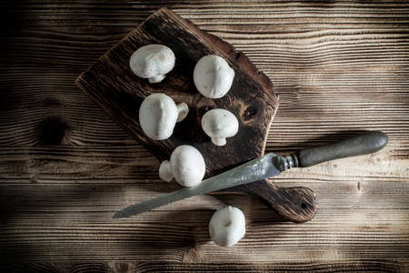 Fresh raw mushrooms on a wooden chopping board. Top view.の写真素材