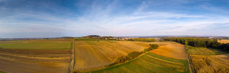 Autumnal fields and forests in the setting sun.の写真素材