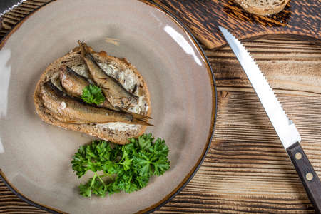 Sandwich with sprats on wooden table.の写真素材