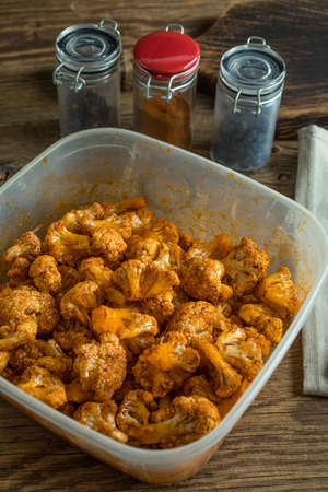 Cauliflower rosettes in a herbal marinade prepared for baking.の写真素材