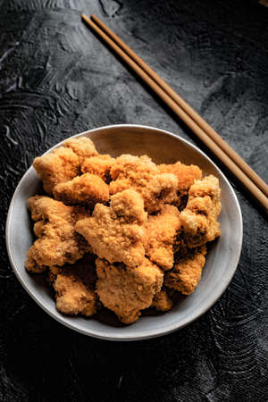 Delicious crispy fried chicken breast strips on concrete table.