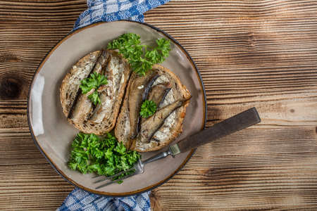 Sandwich with sprats on wooden table. Top view.の写真素材
