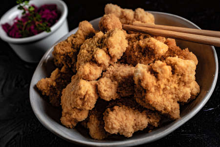 Delicious crispy fried chicken breast strips on concrete table.