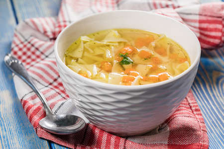 Broth - chicken soup with noodles in a bowl.の写真素材