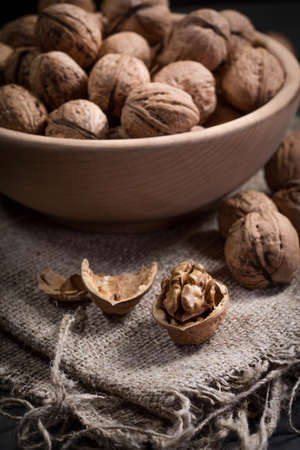 Whole walnuts in a wooden bowl. Shallow depth of field.の写真素材