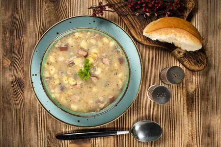 The sour soup made of rye flour with sausage and potatoes. Small depth of field.