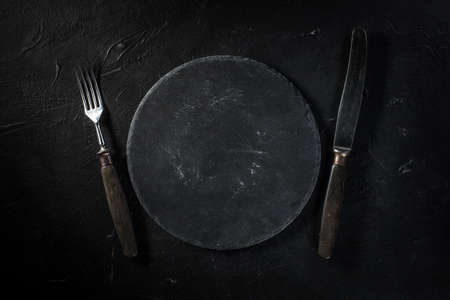 A few old cutlery on dark countertop.の写真素材