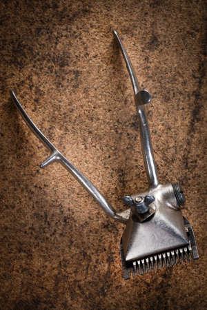 Vintage manual hair clipper on wooden background. Selective focus.の写真素材