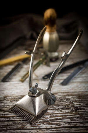Vintage manual hair clipper on wooden background. Selective focus.の写真素材