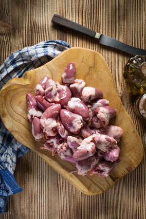 Fresh raw chicken hearts on wooden board.の写真素材