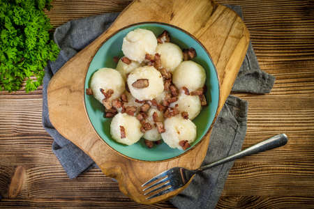 Meat stuffed potato dumplings with fried onion and greaves.の写真素材