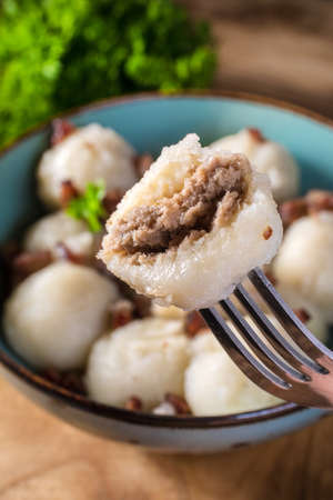 Meat stuffed potato dumplings with fried onion and greaves.の写真素材